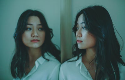 Asian woman looking at reflection