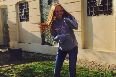 Redhead in a fighting position with her hands tucked into her hoodie sleeves