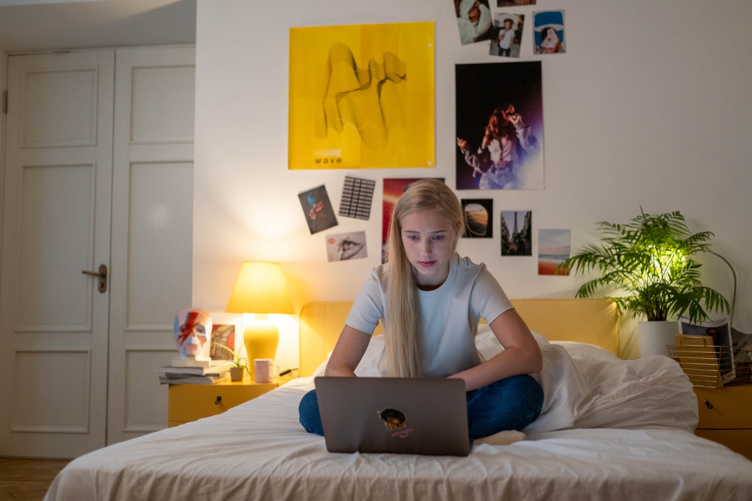 teenager using their laptop in their room