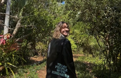 Isabella Sodre in a black jacket with a Treat People With Kindness tote bag