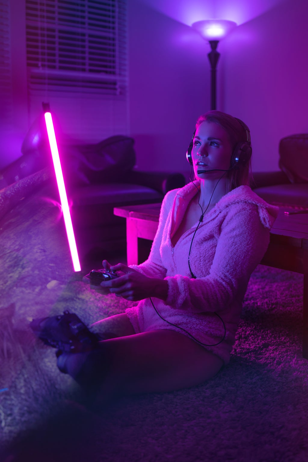 Woman playing a video game with purple lighting in the background