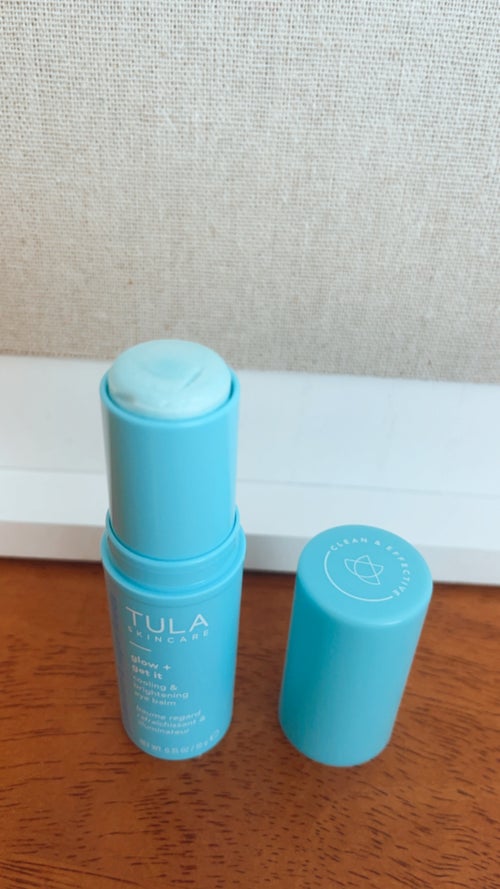 This is an image of a Tula eye cream bottle with the cap off, displaying that the cap lists it as \"clean and effective\"