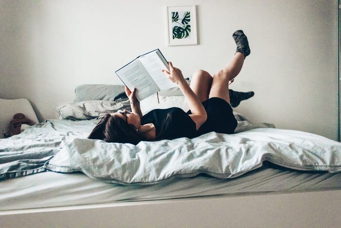 Girl laying on bed reading book by Nicole Wolf?width=698&height=466&fit=crop&auto=webp