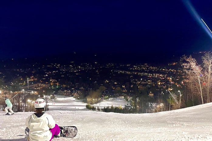 sitting on the top of a ski hill with the view of the chalet\'s and taverns in the distance