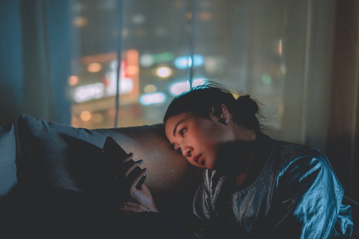 woman scrolling through phone late at night by Mikotoraw?width=698&height=466&fit=crop&auto=webp