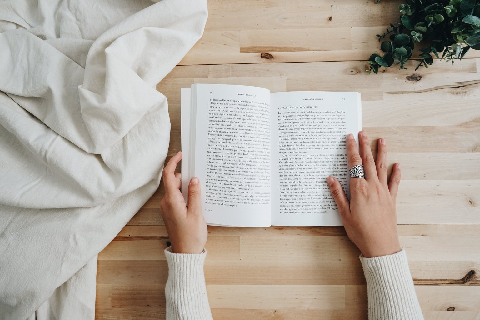 a book a wooded surface with hands