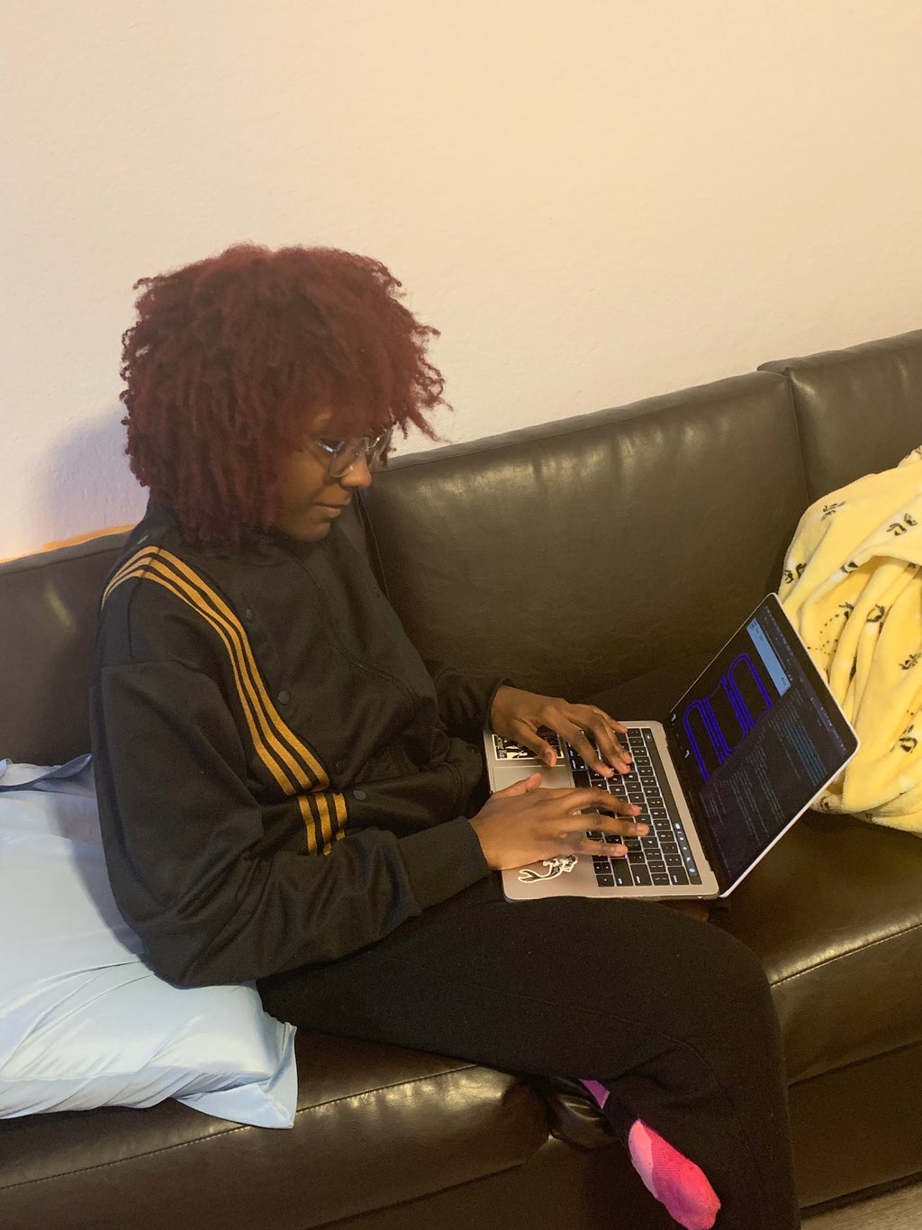 Chance Onyiorah sitting on a sofa and working on her laptop.