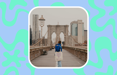 woman in 20s standing on city bridge