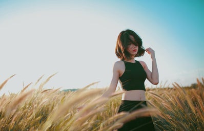 Woman poses in a windy field.