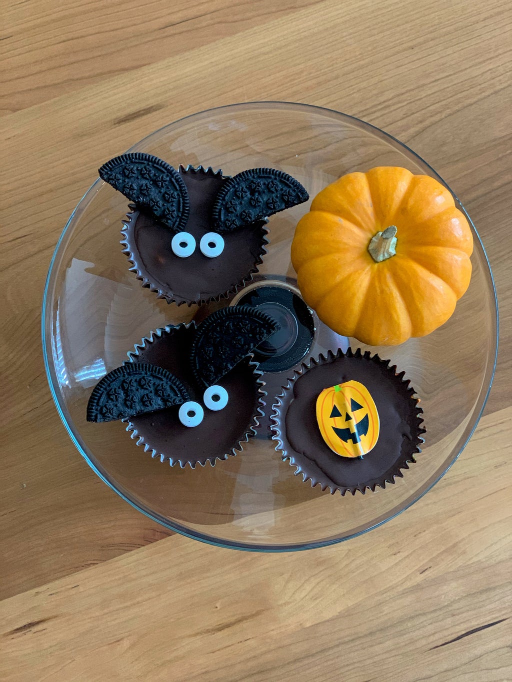 Halloween themed peanut butter cups and a pumpkin on a cake stand.