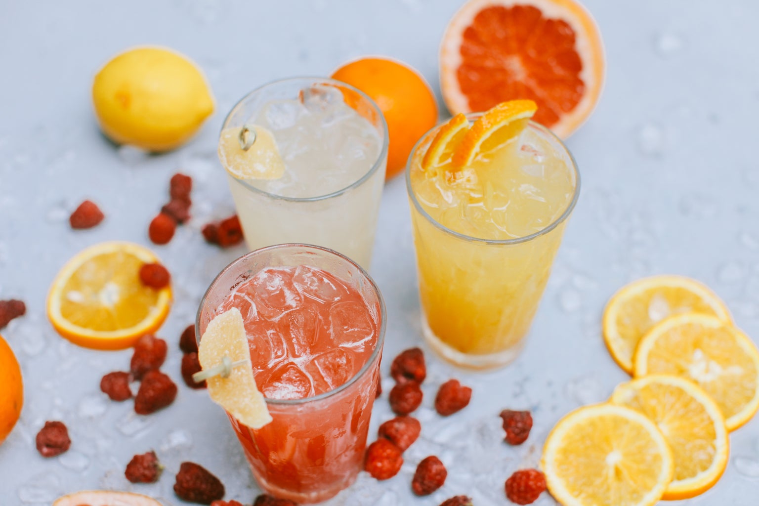 Three glasses of citric cocktails, with grapefruit and lemon