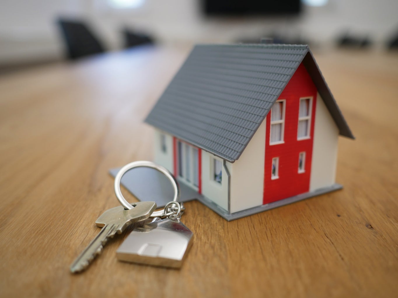 small house model and house key to represent real estate career