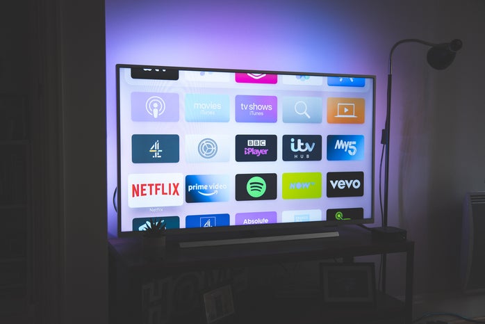 a tv screen with purple lights in the background. there are multiple apps displayed in the tv