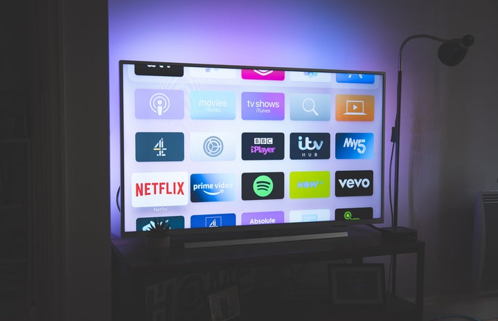 a tv screen with purple lights in the background. there are multiple apps displayed in the tv