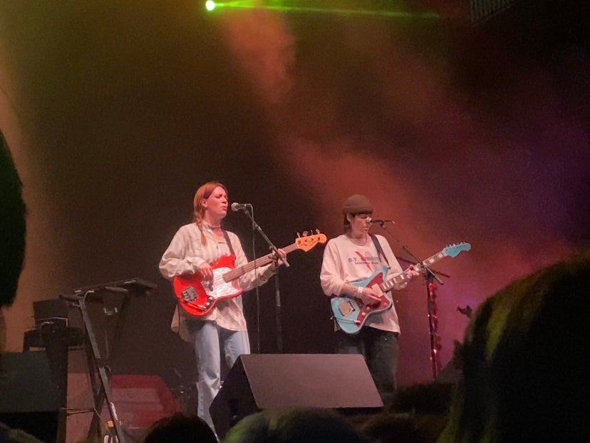 Photo of two musicians playing guitar at a concert.
