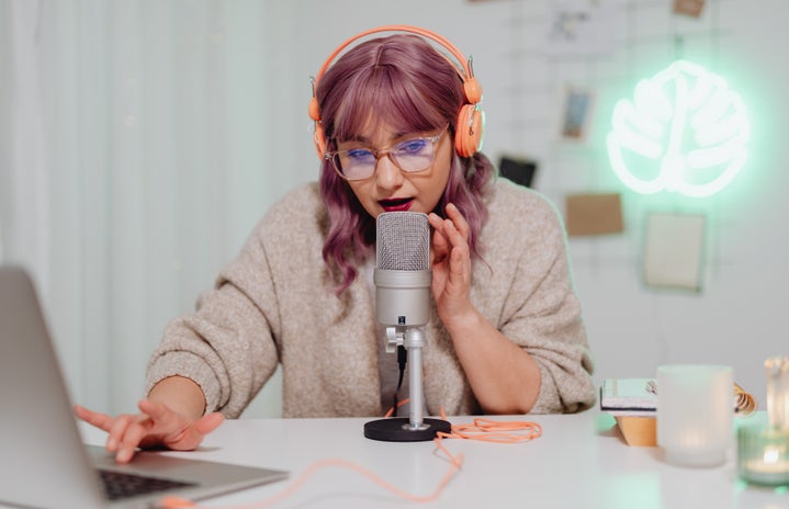 woman with purple hair speaking into a microphone