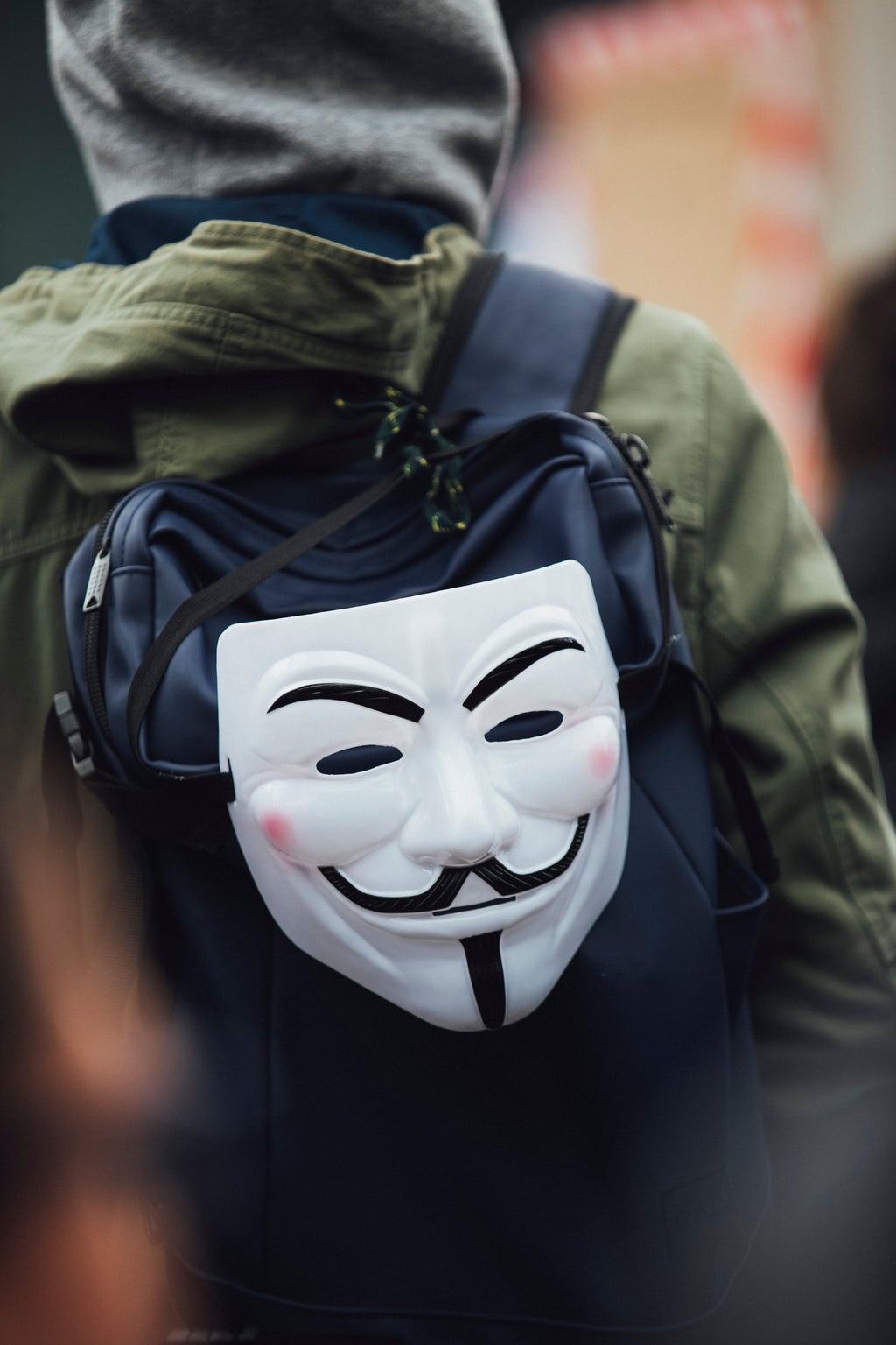 guy fawkes mask hanging off a backpack