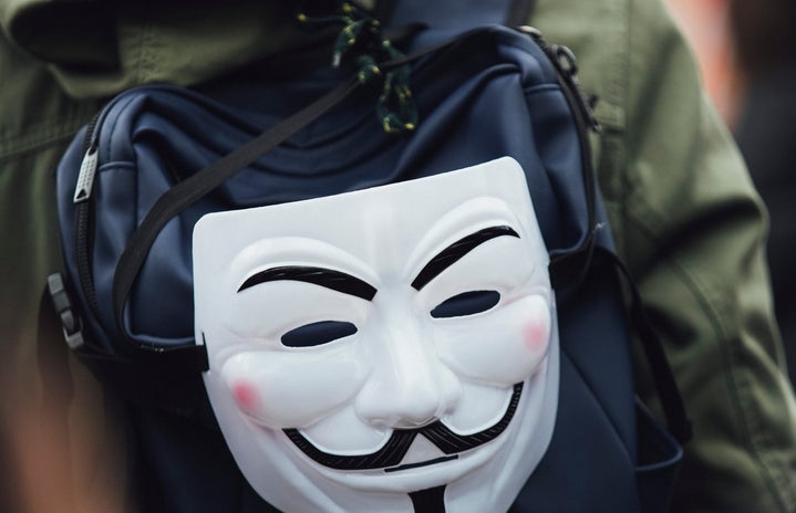 guy fawkes mask hanging off a backpack