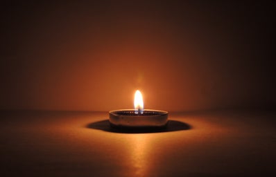 candle burning in a small ceramic bowl