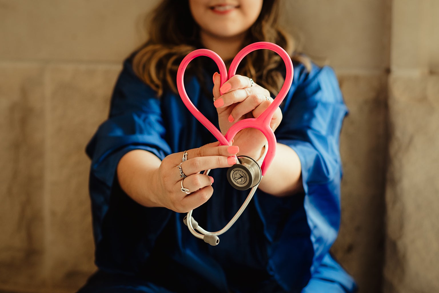Woman holding stethoscope in shape of heart