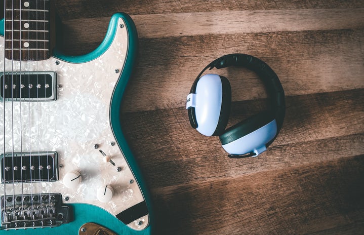 headphones next to a guitar