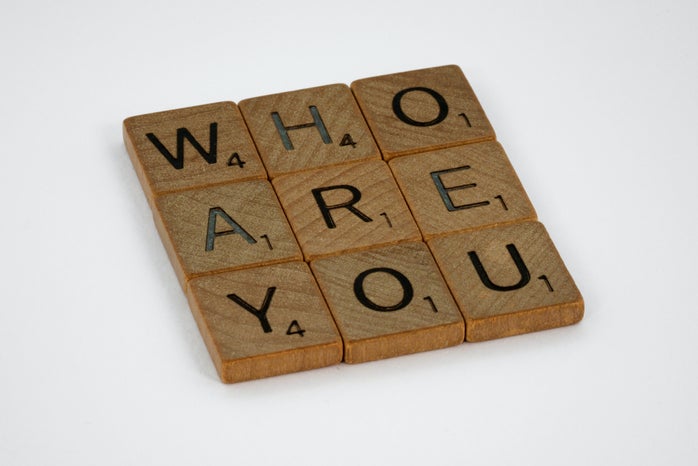 scrabble pieces spelling out the question \"Who are you?\" on a white background
