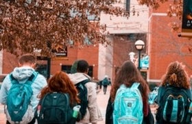 Kids walking with backpacks in front of school