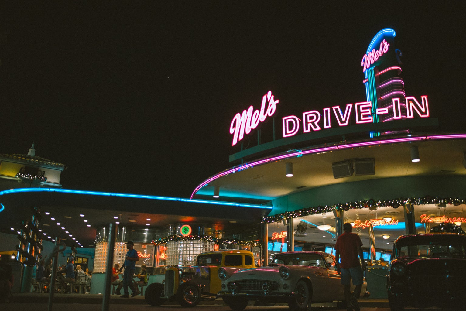 drive-in diner with neon signs and cars