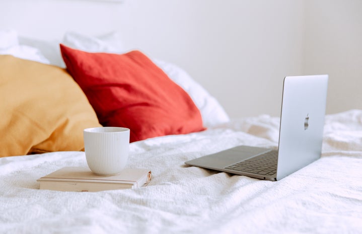 laptop on bed with a mug and book by Tatiana Syrikova?width=719&height=464&fit=crop&auto=webp