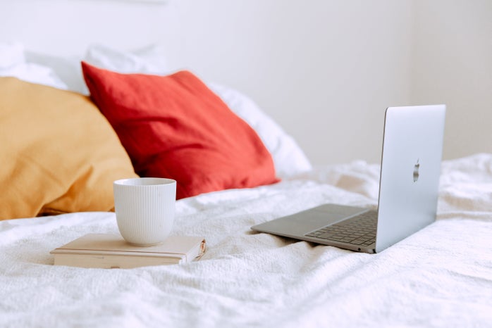 laptop on bed with a mug and book by Tatiana Syrikova?width=698&height=466&fit=crop&auto=webp