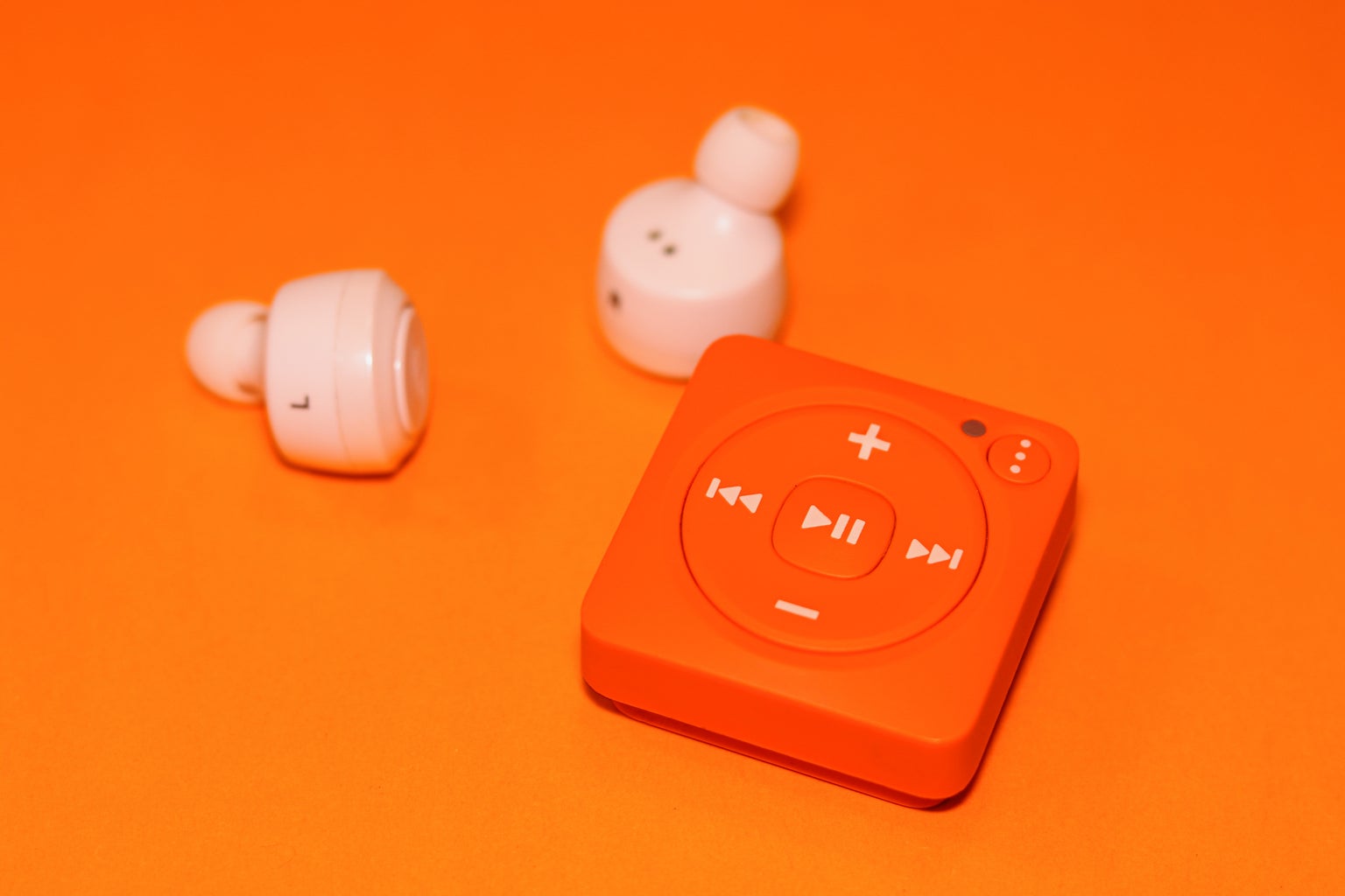 Orange background with mp3 player and earbuds