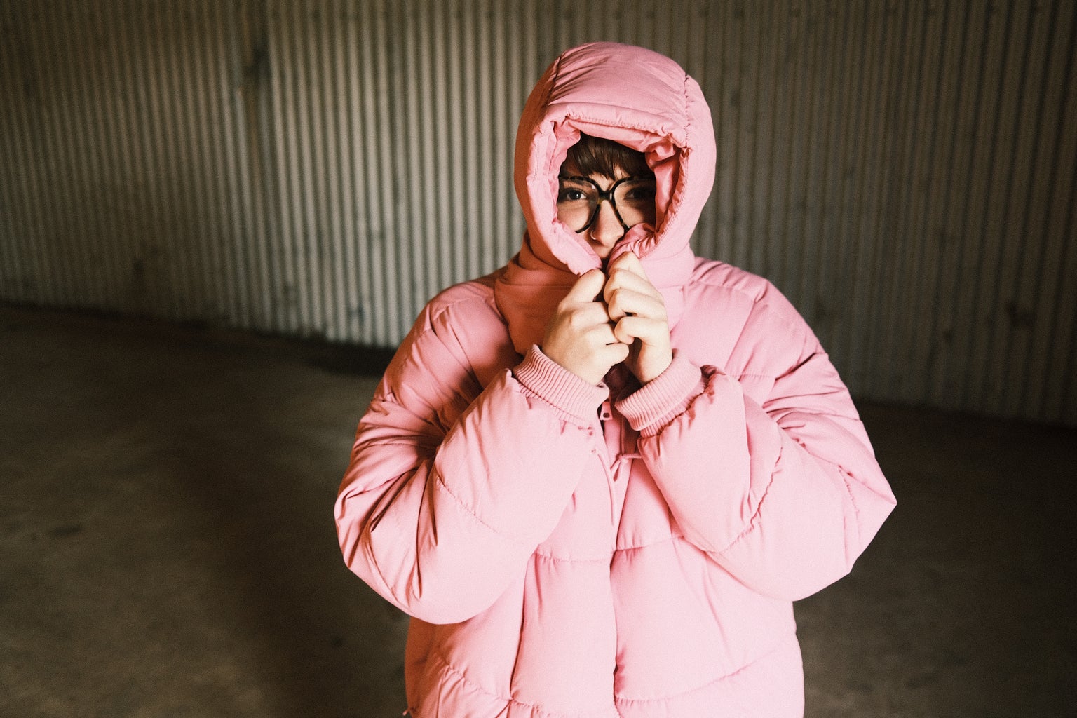 Picture of woman with glasses wearing pink puffer jacket