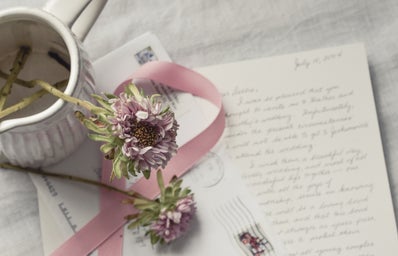flowers in vase over handwritten letter