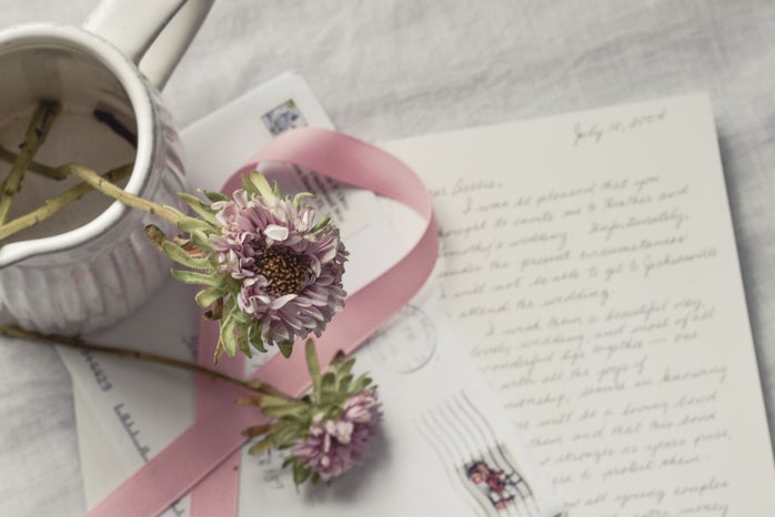 flowers in vase over handwritten letter