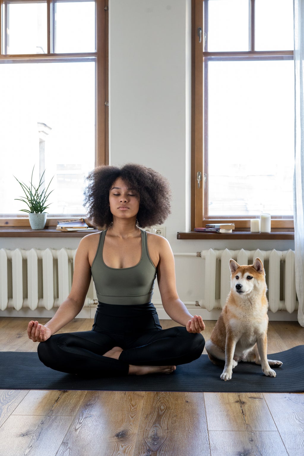 woman meditating with dog beside her