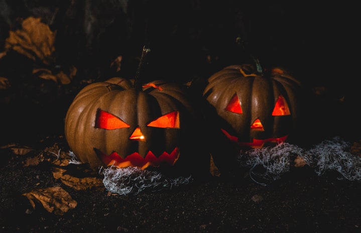 two spooky jack-o-lanterns lit up in the dark