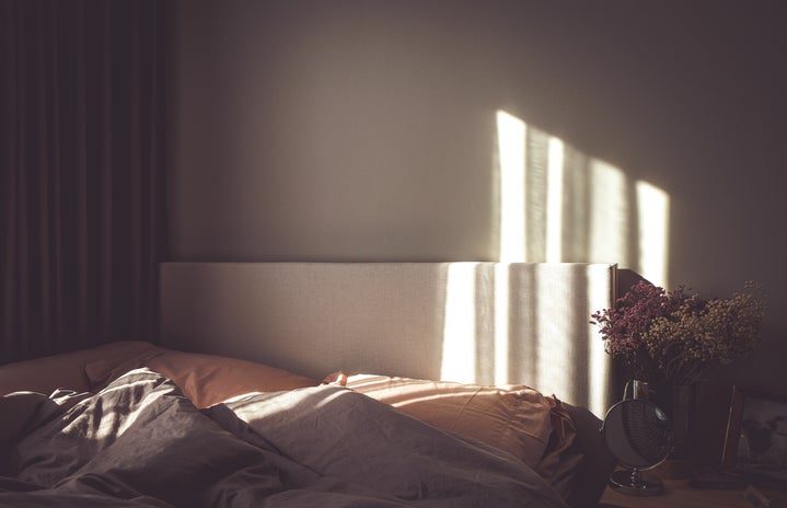 empty bed with sunlight on wall