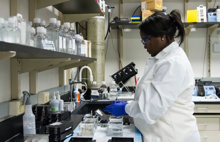 black woman in lab coat working in a lab