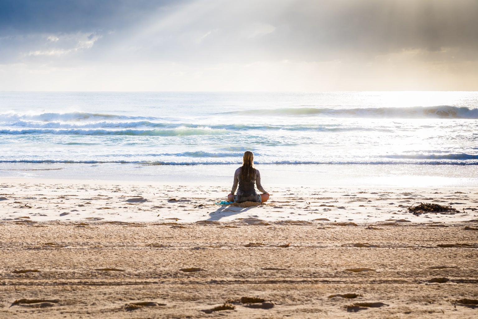woman meditating on the beach