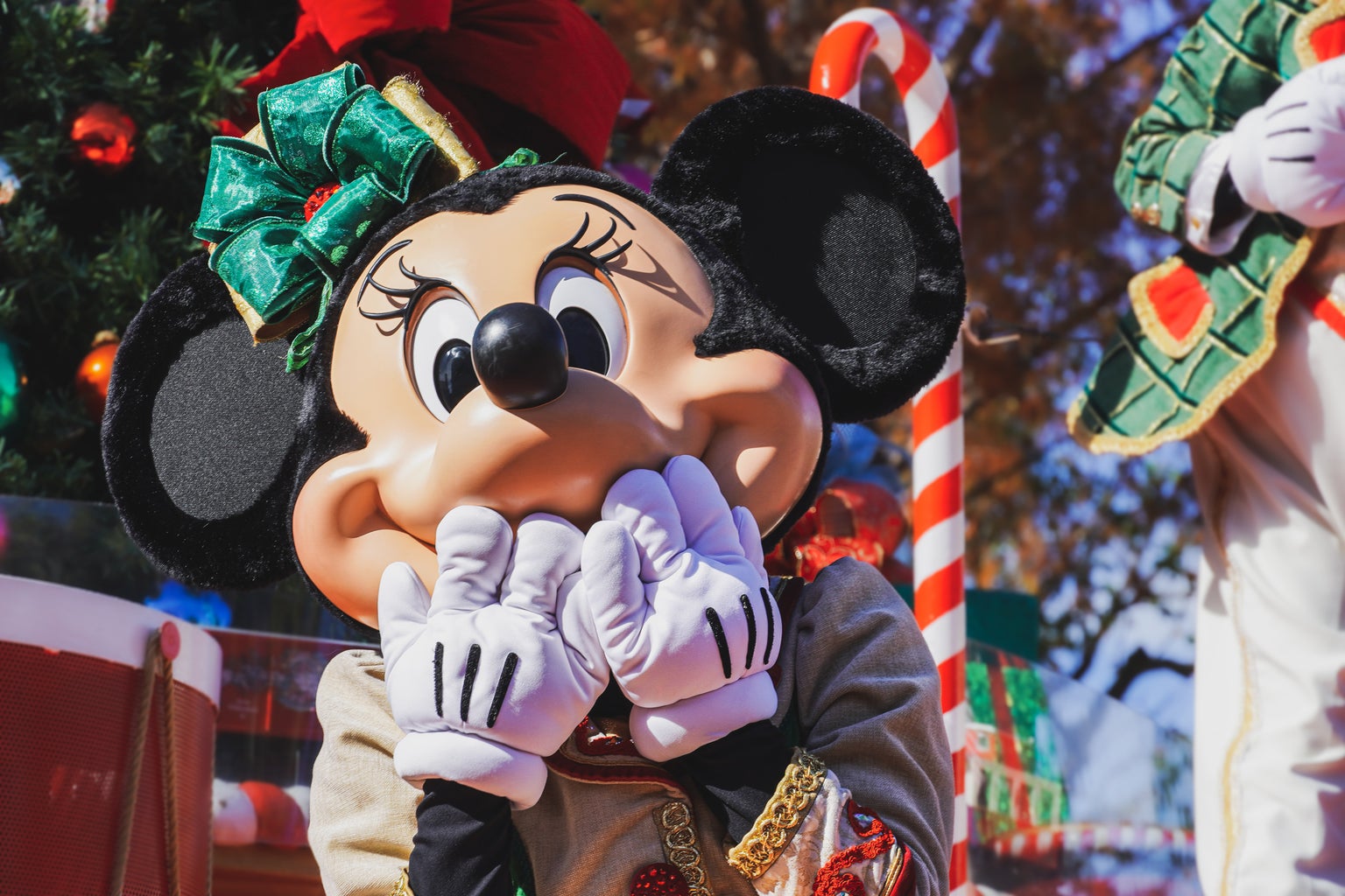 Minnie Mouse dressed in Christmas attire in a Disney park