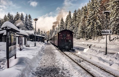 a train pulling into a station during the winter
