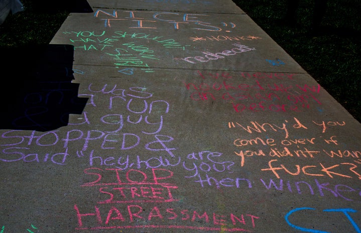 Chalk written on the sidewalk by students and community members discussing sexual harassment