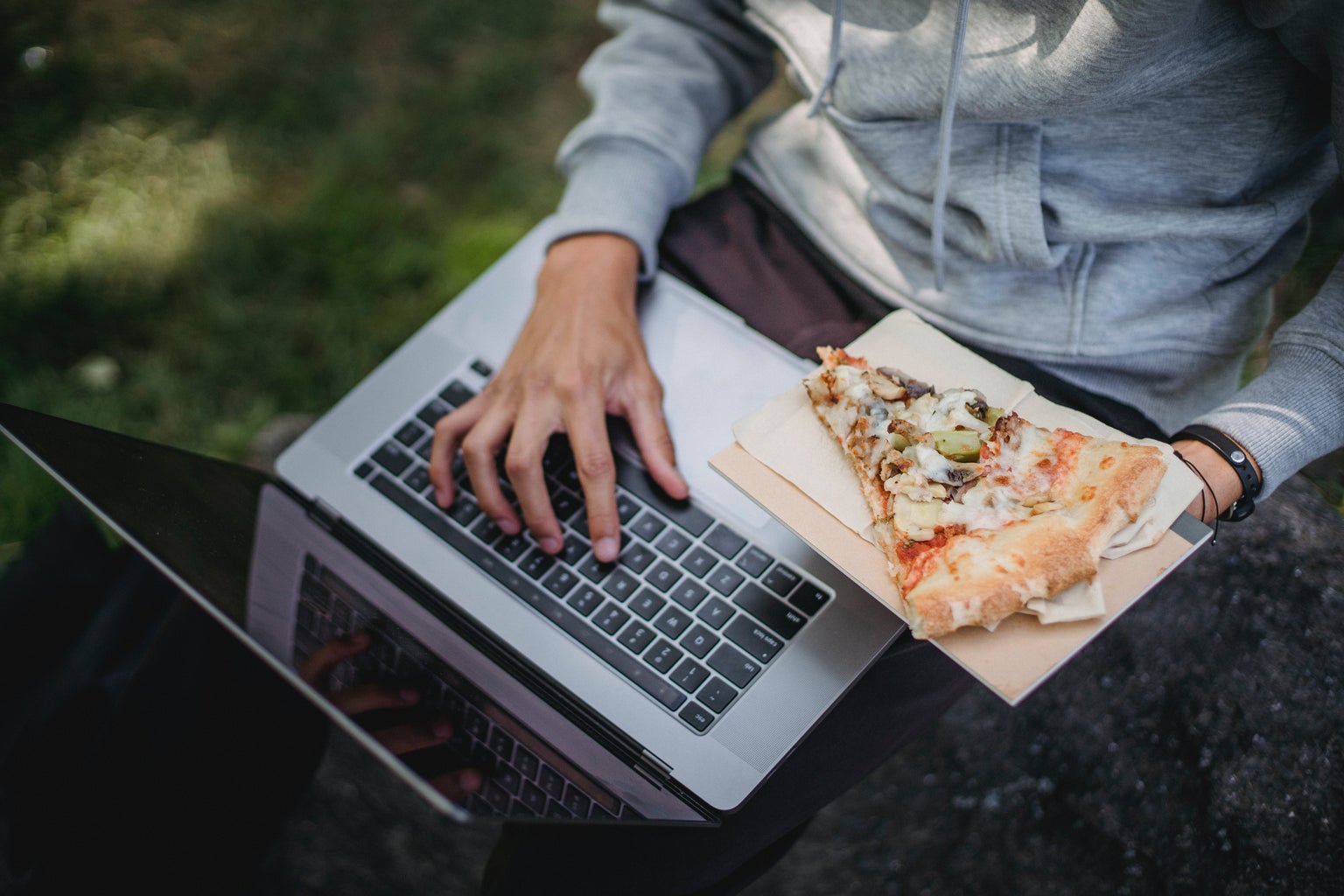 Guy holding pizza on computer.
