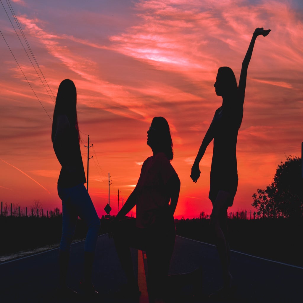 three silhouettes in the middle of the road