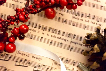 Christmas craft supplies with scrapbook paper, holly and an embroidery hoop