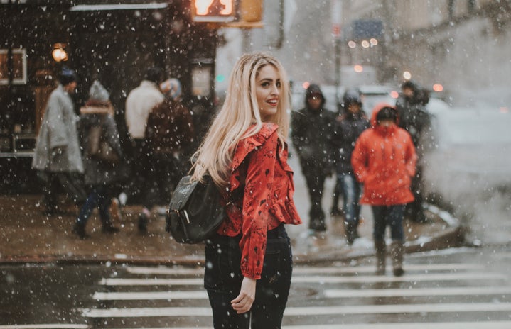 woman walking across the street in the snow