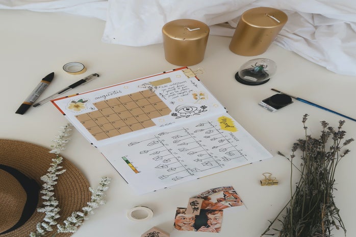 bullet journal with two gold pillar candles by Este Janssens?width=698&height=466&fit=crop&auto=webp