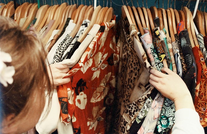 girl sorting through clothes rack