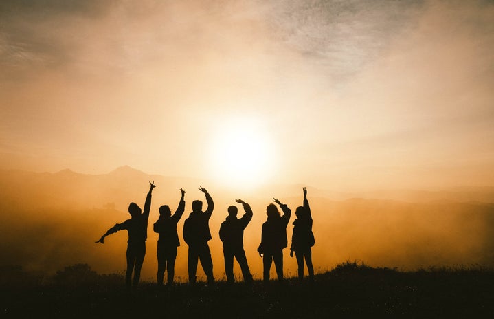 Silhouette of group of friends facing the sun