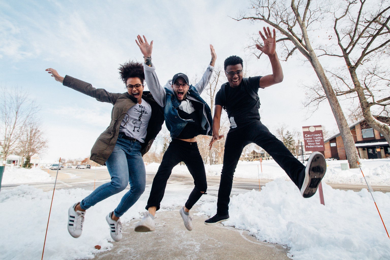 Three people jumping joyfully on snowy day